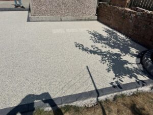 Charcoal kerb border around a light resin patio in St Annes